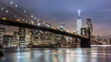 Fototapeta Panele - Brooklyn bridge and New York City Manhattan downtown skyline at dusk with skyscrapers illuminated over East River panorama.