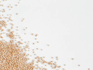 Wall Mural - Grain of real quinoa isolated on white background. Uncooked raw quinoa as background. Healthy vegan food concept and pattern. Copy space. Top view or flat lay. Isolated one edge.