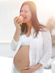 Canvas Print - smiling pregnant woman with an Apple