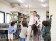 © Nattanon - Happy Children and teacher in Learning Class at Library. Boy raised hand up his hand to answer a question from teacher. Setup studio shooting.
