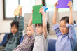 © Nattanon - Happy Four of Children Sitting on Chair with a Book in hand in Library. Development of Human Resources in Education Concept. Setup studio shooting.