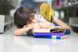 © Nattanon - Little boy has bored to study and sleeping on the Book stack. Children has lazy learning class in Library. Development of Human Resources in Education Concept. Setup studio shooting.