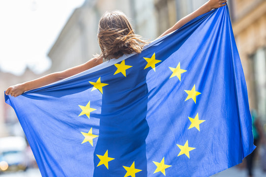 eu flag. cute happy girl with the flag of the european union. young teenage girl waving with the eur