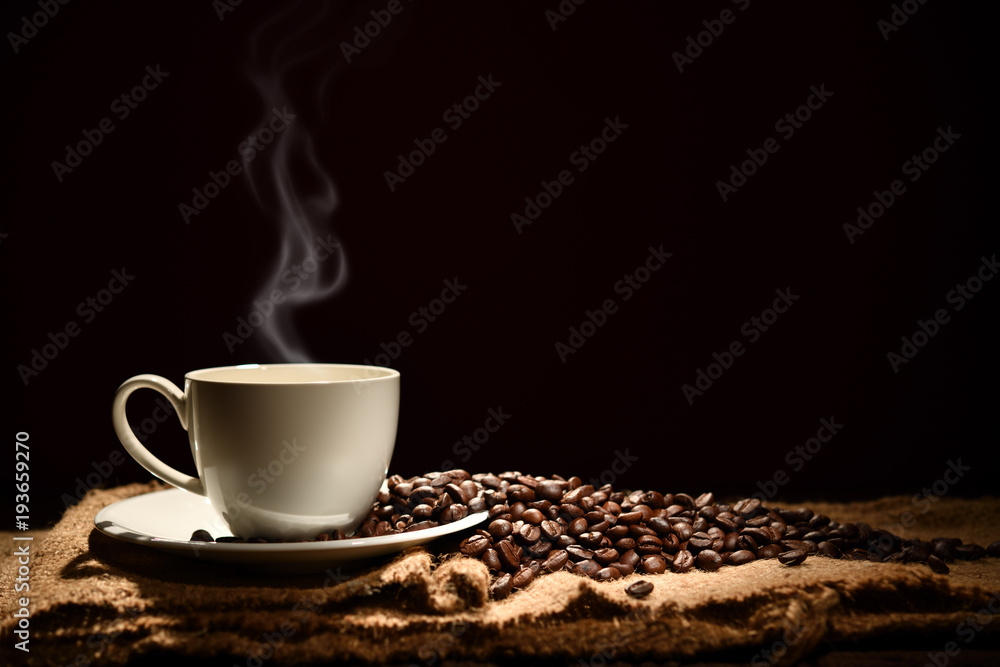 Obraz na płótnie Cup of coffee with smoke and coffee beans on black background w salonie