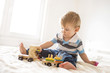 © Drpixel - Little adorable boy playing with wooden train toy in bedroom