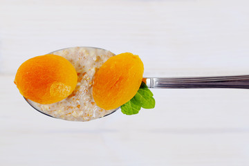 Poster - spoon of oatmeal porridge with apricots