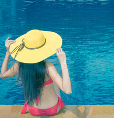 happy bikini woman ware hat and two piece swimsuits relaxing near pool and sea in sunny day