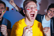 © Karanov images - Soccer or football fans watching the match at home, cheering and celebrating goal