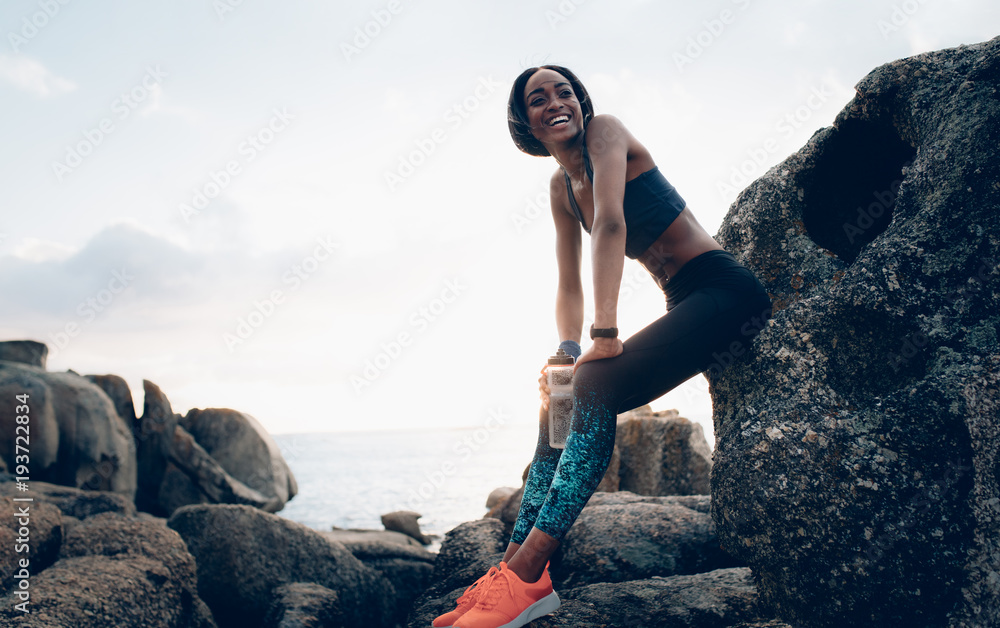 Smiling woman resting outdoors after workout - obrazy, fototapety, plakaty 