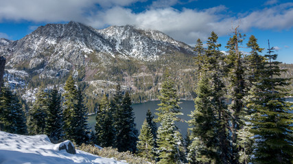 View of the west side of Lake Tahoe with mountains in the background and little snow in the end f the winter of 2018