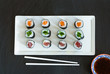 A selection of sushi rolls with salmon, tuna and cucubmer with soy sauce dip - top view.