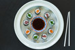 A selection of sushi rolls with salmon, tuna and cucubmer with soy sauce dip.