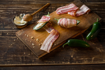 Wall Mural - Cooking spicy peppers with cheese and meat bacon. Food recipe on wooden background.