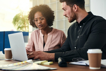 Focused colleagues working online together at an office desk