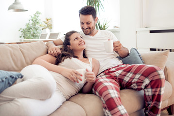 Young couple sitting on sofa at home