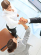 © ASDF - view from the top.members of the business team giving each other a high five above the Desk.