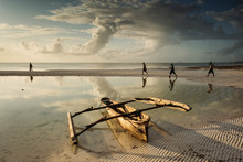 Fishermen Going On Ocean On Traditional Fishing Boat In Zanzibar With Storm Clouds At Sunrise