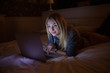 © lashkhidzetim - A sexy woman lying on bed with laptop at home