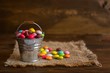 color candy dragee in a decorative bucket on a napkin from burlap