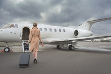 Full Length Female Keeping Baggage While Going To Private Jet. She Turning Back To Camera. Trip Concept