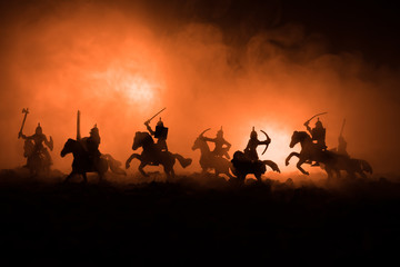 Wall Mural - Medieval battle scene with cavalry and infantry. Silhouettes of figures as separate objects, fight between warriors on dark toned foggy background. Night scene.