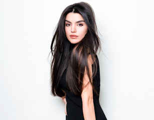 beautiful young woman with long black hair posing in black knit dress