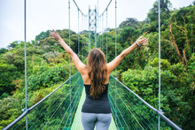 Woman With Arms Raised On Hanging Bridges Of Costa Rica