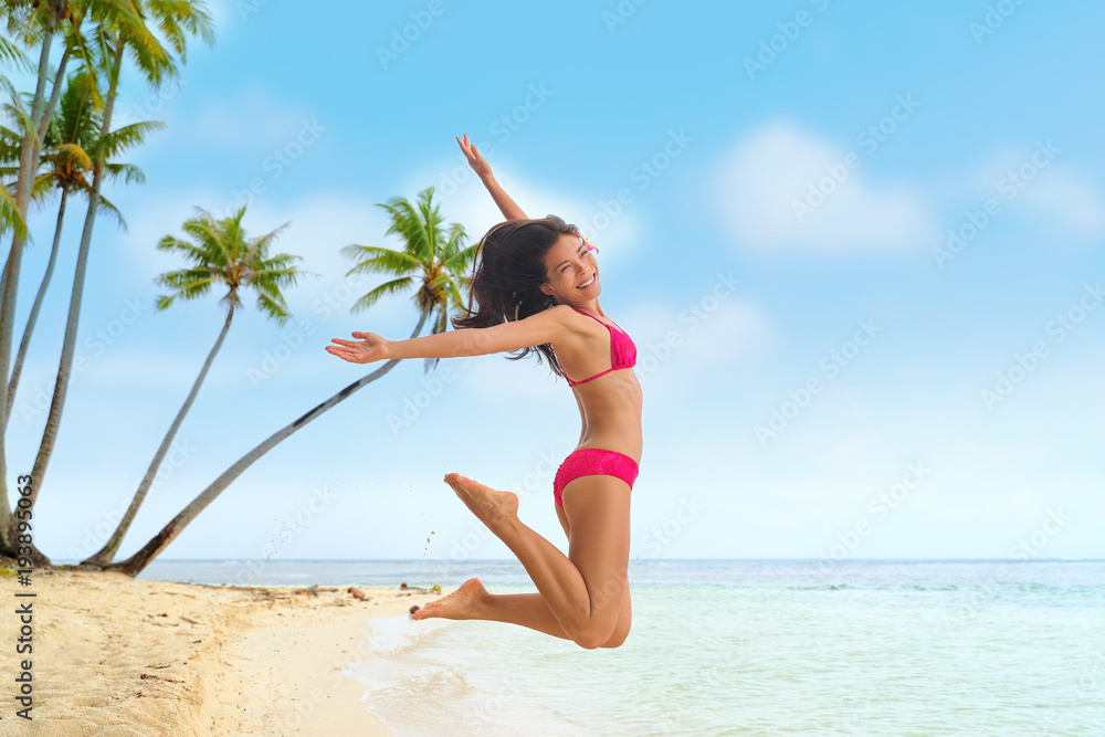 Photo Stock Beach fun summer vacation under the sun joyful happy bikini  woman jumping of joy on Tahiti luxury travel destination. Asian girl  happiness jump. | Adobe Stock