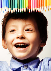 little cute boy with color pencils close up smiling, education f