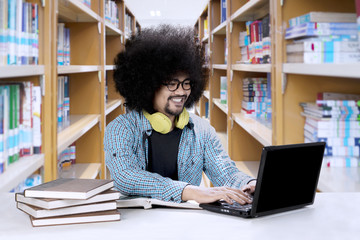 Wall Mural - Afro student studying in the library