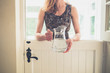 © LoloStock - Woman with jug of water by stable door