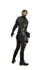 full length portrait of female  soldier wearing black  tactical armour  facing away from camera, isolated on white studio background.