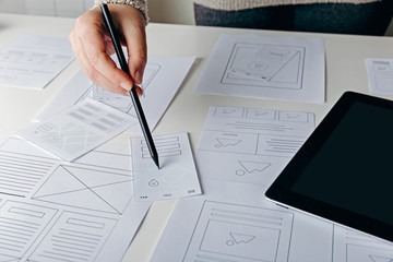 Wall Mural - web designer creating mobile responsive website. website wireframe sketches on white table