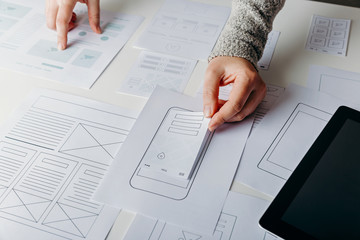 Wall Mural - web designer creating mobile responsive website. website wireframe sketches on white table