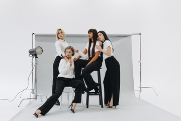 four women posing on grey background