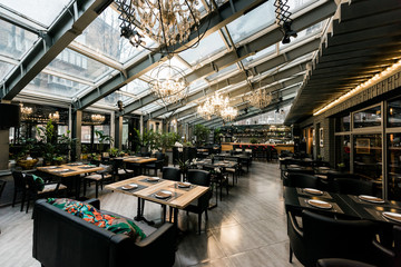 View of stylish empty cafe with arranged tables and chairs for visitors