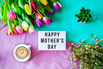  Happy mother's day written in lightbox with spring flowers from above