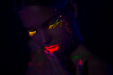 Fototapeta  - Portrait of Beautiful Fashion Woman in Neon UF Light. Model Girl with Fluorescent Creative Psychedelic MakeUp, Art Design of Female Disco Dancer Model in UV, Colorful Abstract Make-Up