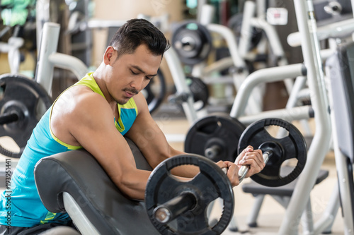 Young Handsome Man Exercising Bicep Curls With The E Z Barbell