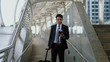 © pixs4u - Asian young businessman with baggage and looking paper map in hand