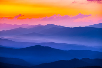 quiet mountain valley in a blue mist at the sunset