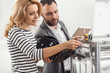 © Viacheslav Yakobchuk - Perfect explanation. Charming senior engineer teaching his female colleague how to insert filament into extruder while the woman holding a spool and following his instructions