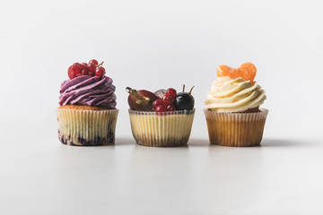 close up view of various sweet cupcakes isolated on white