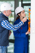 © auremar - female builder with spirit level at site