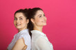 © Alexandr - two beautiful young sisters twin girls with a smile on a pink background