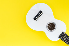 White Ukulele On A Yellow Background And With A Place For Text. Musical Concept.