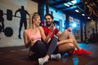© Nebojsa - Fit couple in modern crossfit gym with smartphone listening to the music.