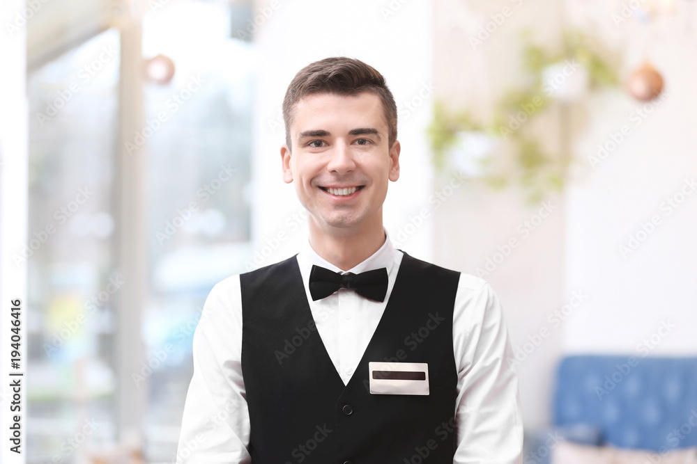 Attractive young waiter at workplace
