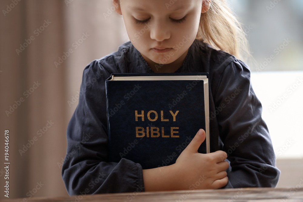 Religious Christian girl with Bible indoors