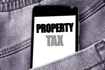 Hand writing text caption inspiration showing Property Tax. Business concept for Estate Income Taxation written mobile cell phone with copy space in the back pants trousers pocket